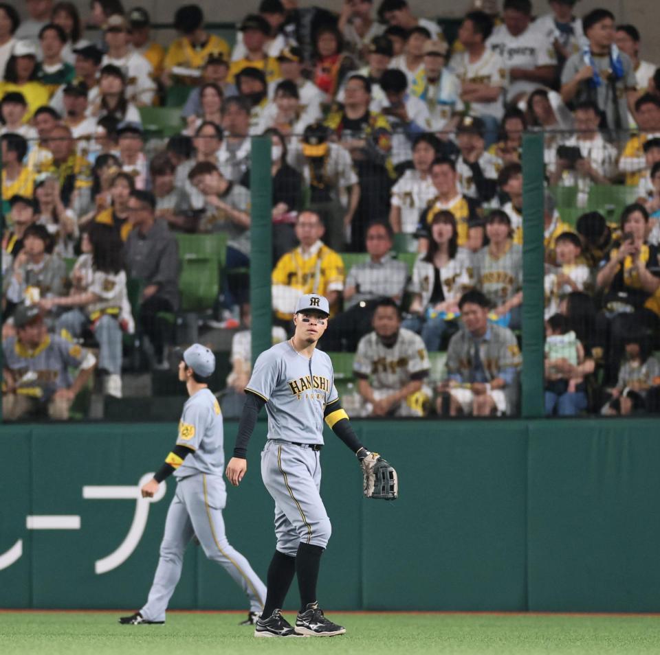 　２回、山村の打球を後逸し、守備位置へ戻る佐藤輝。ざわつくスタンド（撮影・田中太一）