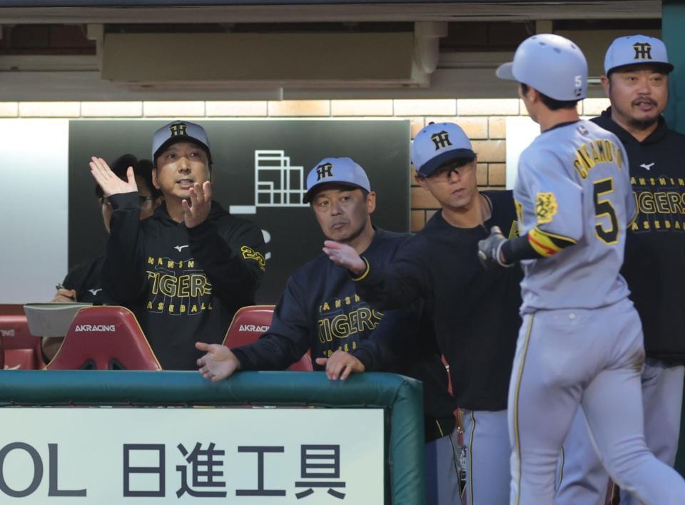 　３回、森下の先制打で生還した近本（右）を拍手で迎える藤川監督（左）＝撮影・西岡正