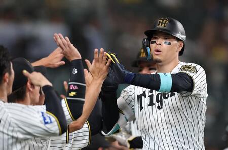 　８回、２ランを放ち、ナインとタッチを交わす佐藤輝（撮影・北村雅宏）