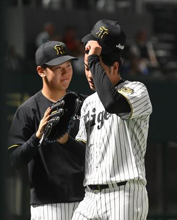 　９回を投げ終え、門別（左）に迎えられる高橋（撮影・西田忠信）