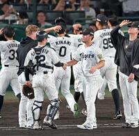 　連敗を止める活躍で勝利投手となり、坂本（１２）と握手を交わす伊藤将（撮影・立川洋一郎）