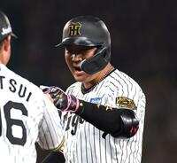 　７回、適時打を放った大山（右）は筒井コーチとグータッチを交わす（撮影・北村雅宏）