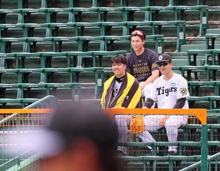 　スタンドに腰かけシートノックの様子を見る（左から）才木、湯浅、大竹（撮影・立川洋一郎）