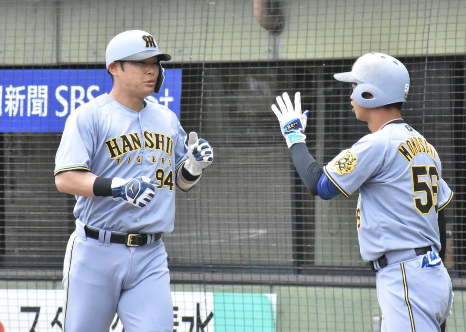 　本塁に生還し、ハイタッチする原口