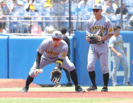 　三塁でシートノックを受ける佐藤輝（左）＝撮影・西岡正