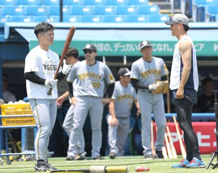 　試合前練習で高橋（右）と話す坂本（撮影・西岡正）