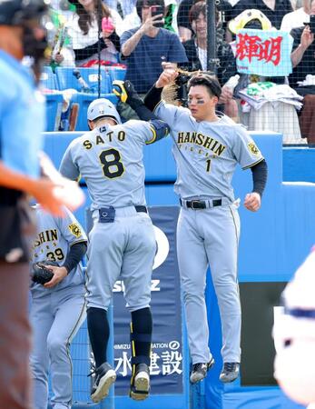 　８回、ソロを放ち、森下（右）とタッチを交わす佐藤輝（撮影・西岡正）