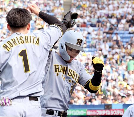 　８回、生還した佐藤輝は森下とタッチを交わす（撮影・田中太一）