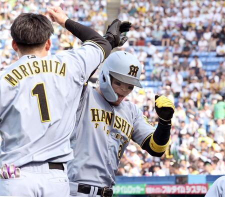 　８回、ソロを放った佐藤輝は森下とタッチを交わす（撮影・田中太一）