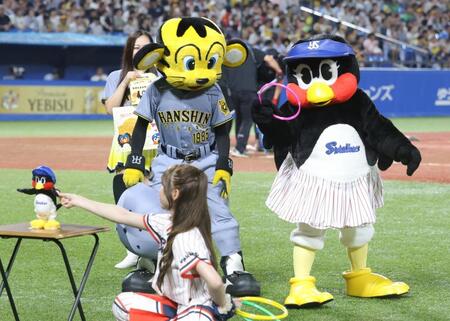 　トラッキー（左）と輪投げ対決で狙いを定めるつばみ＝２７日