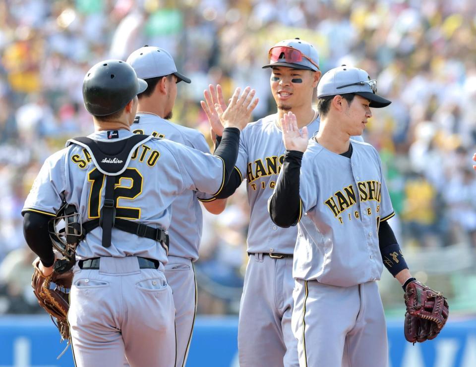 　ヤクルトに連勝し、ナインとタッチを交わす佐藤輝（左から３人目）＝撮影・西岡正