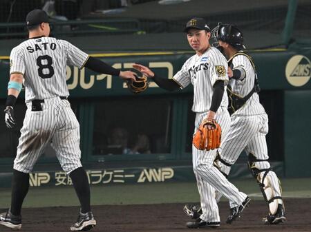 　８回、好リリーフを見せ佐藤輝（８）らとタッチを交わす石井（撮影・飯室逸平）