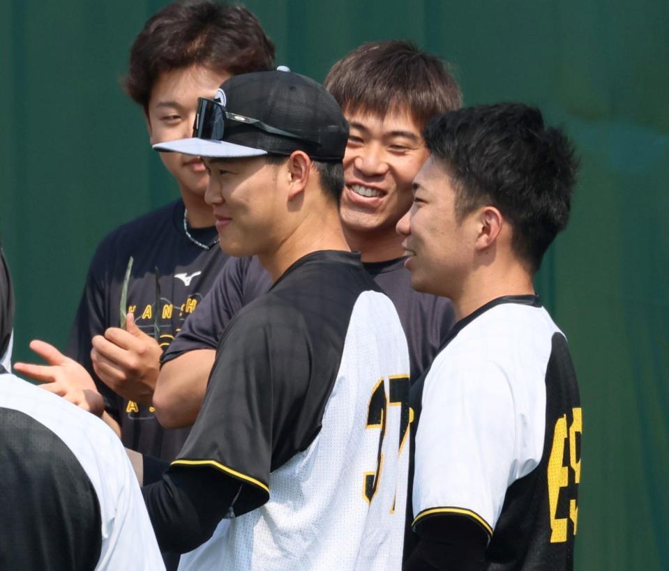 　１軍に合流してナインに迎えられ笑顔を見せる石井（右）＝撮影・立川洋一郎