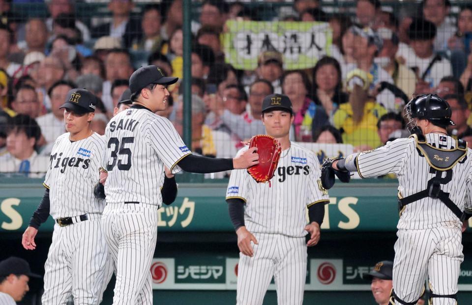 　５回、ピンチをしのぎ梅野（右）とタッチを交わす才木