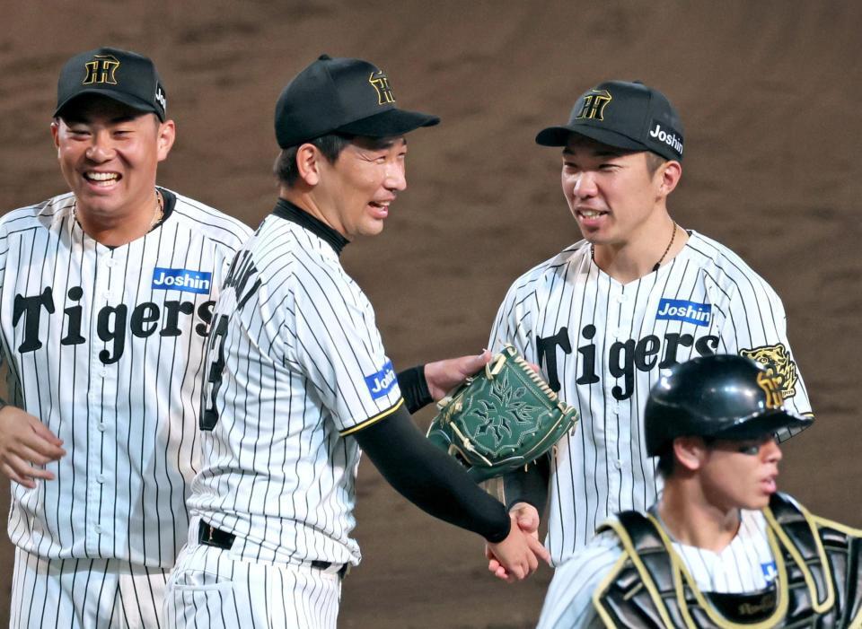 　巨人に勝利し岩崎（中央）と握手を交わす石井（撮影・立川洋一郎）