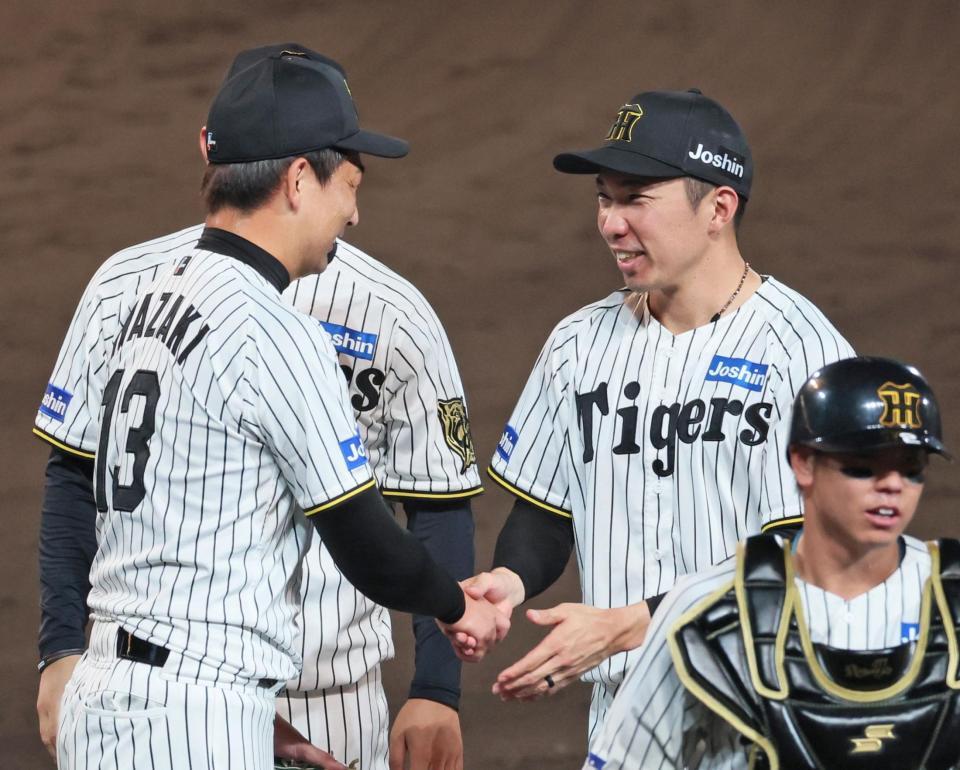 　巨人に勝利し岩崎（１３）と握手を交わす石井（撮影・立川洋一郎）