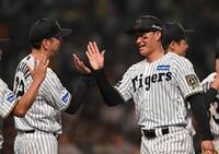 　決勝点となる生還を果たし、藤川監督（左）とタッチを交わす森下（撮影・西田忠信）
