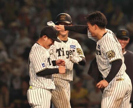 　９回、チームがサヨナラ勝ちし、森下にペットボトルで小突かれる伊原（左）＝撮影・北村雅宏