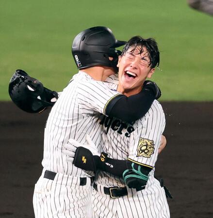 　９回、サヨナラとなる中犠飛を放ち、佐藤輝（左）と抱き合って喜ぶ豊田（撮影・立川洋一郎）