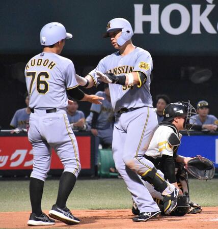 　７回、本塁打を放ちホームで工藤コーチ（左）とハイタッチする原口
