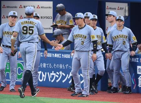 　スタメンを外れ、守備からベンチに戻るナインを迎える大山（中央）＝撮影・金田祐二