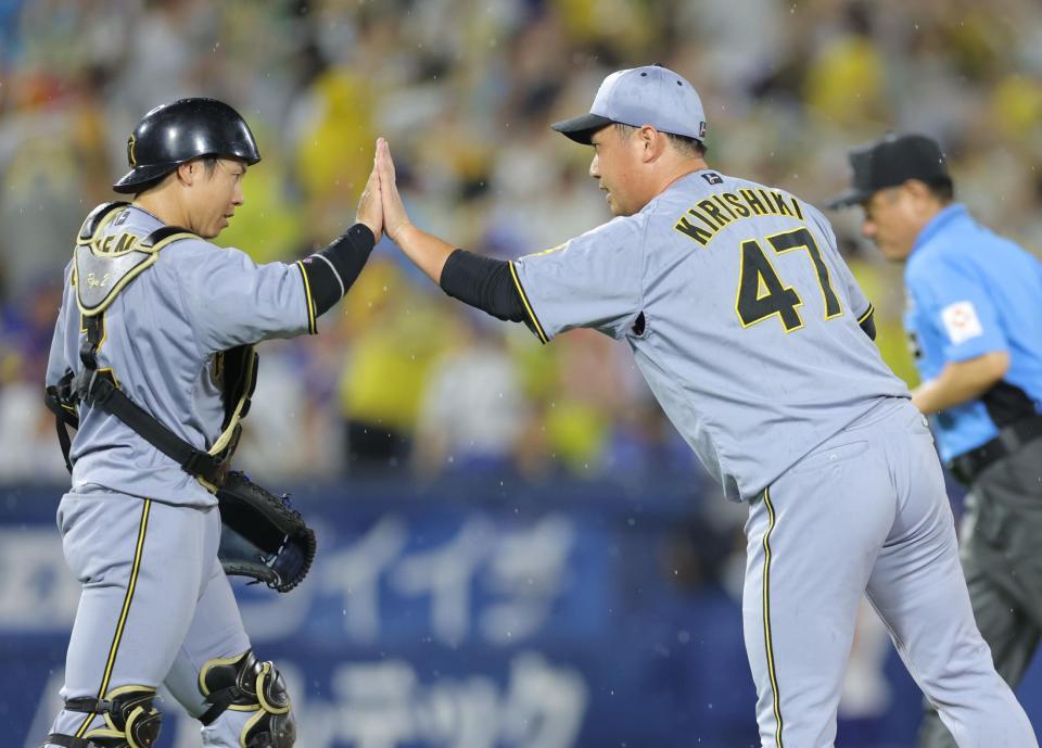 　最後を締め、梅野（左）とタッチを交わす桐敷（撮影・西岡正）