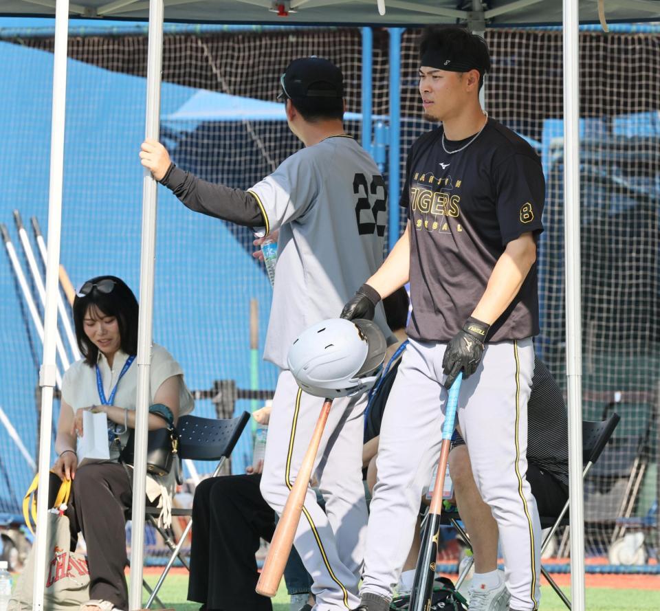 　打撃ケージへ向かう佐藤輝。左奥は勝みなみ（撮影・田中太一）