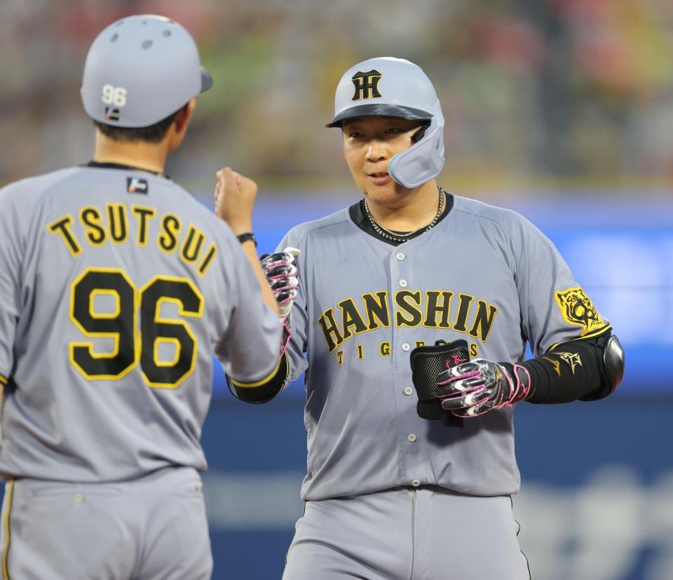 　４回、右前打を放ち、筒井コーチ（左）とタッチを交わす大山（撮影・西岡正）