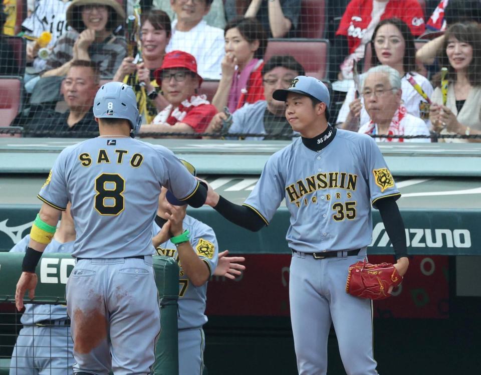 　１回、先制となる２点適時打を放った佐藤輝を迎える才木（右）＝撮影・北村雅宏