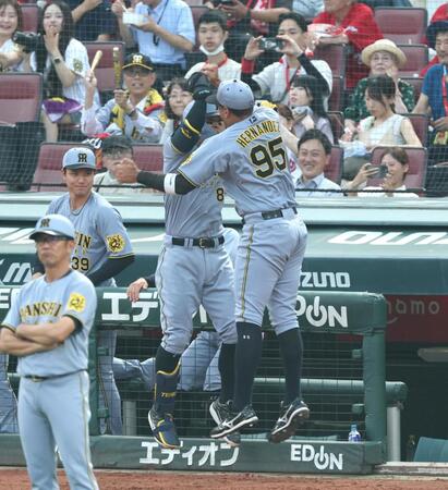 　２回、先制ソロを放った佐藤輝はヘルナンデス（右）とタッチを交わす（撮影・北村雅宏）