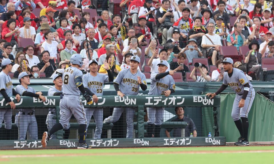 　２回、右越えソロを放った佐藤輝を、出迎える阪神ナイン（撮影・市尻達拡）
