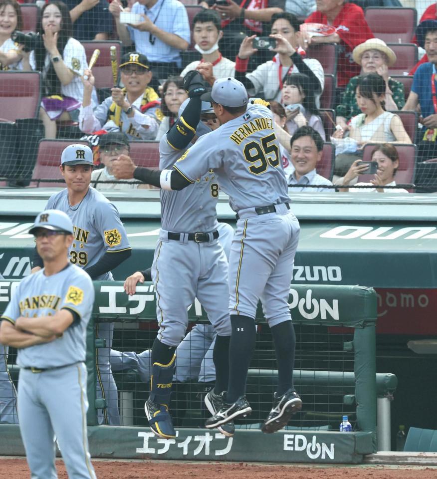 　２回、先制ソロを放った佐藤輝はヘルナンデス（右）とタッチを交わす（撮影・北村雅宏）