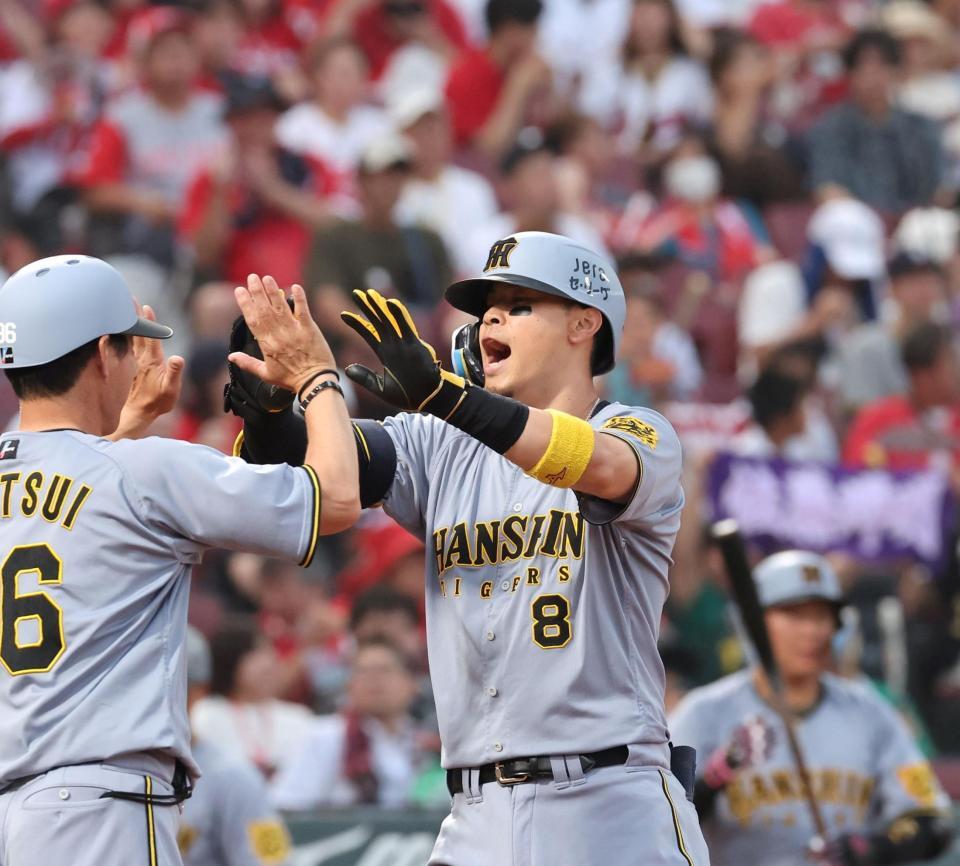 　２回、右越えソロを放ち、タッチを交わす佐藤輝（撮影・市尻達拡）