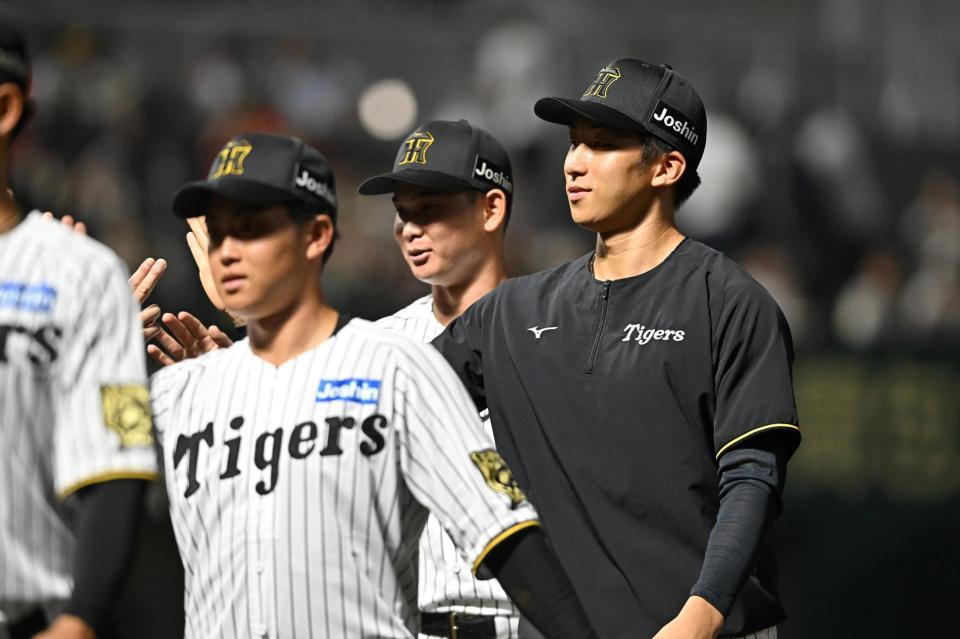 　広島に勝利し、ナインとタッチを交わす茨木（右）＝撮影・西田忠信