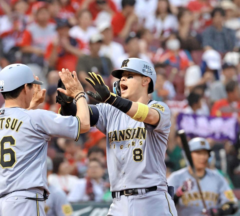 　２回、ソロを放ち、タッチを交わす佐藤輝（撮影・市尻達拡）