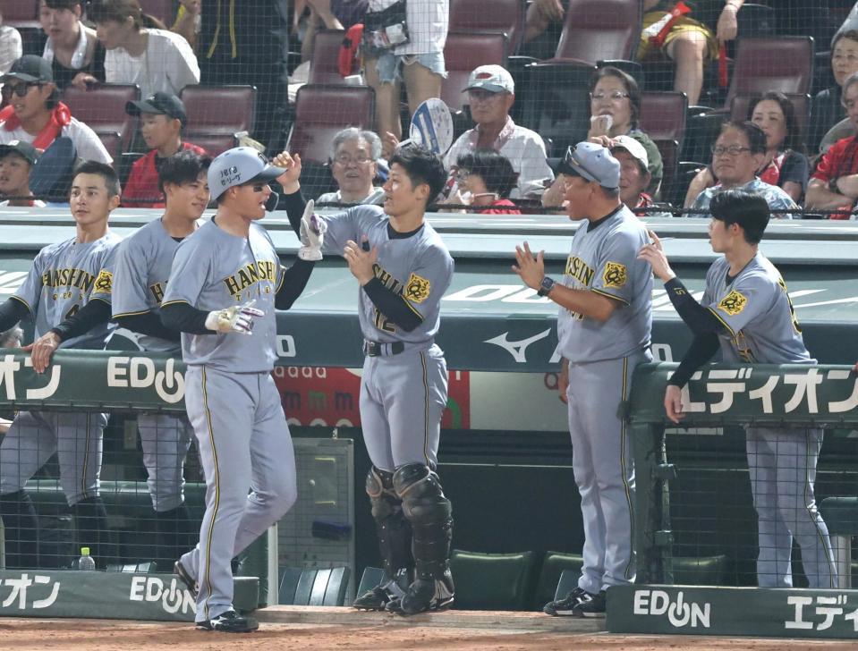 　７回、佐藤輝の適時二塁打で生還し、ナインに迎えられる森下（左から３人目）＝撮影・北村雅宏