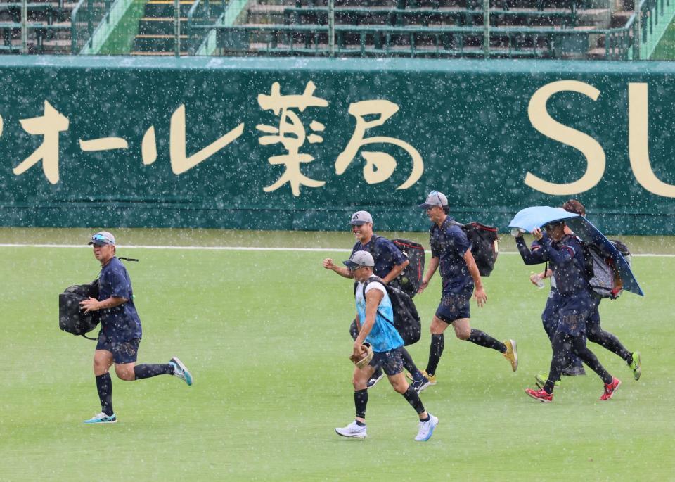 　練習中、急な雨に見舞われ駆け足で引き揚げるヤクルトナイン（撮影・立川洋一郎）