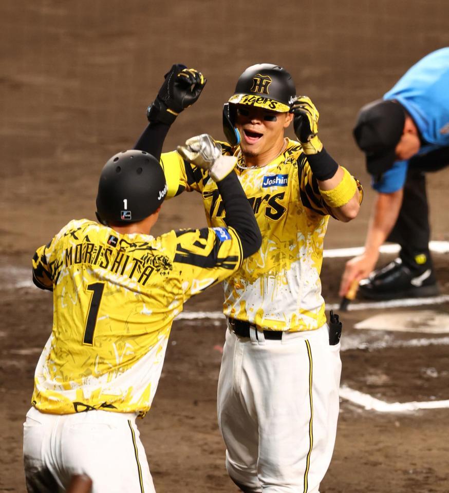 　６回、先制２ランを放ち生還する佐藤輝（右）＝撮影・山口登