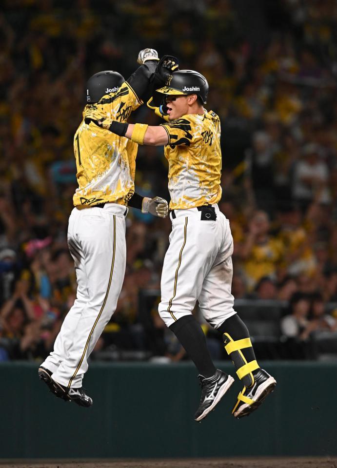 　６回、先制２ランを放ち森下（左）と喜ぶ佐藤輝（撮影・西田忠信）