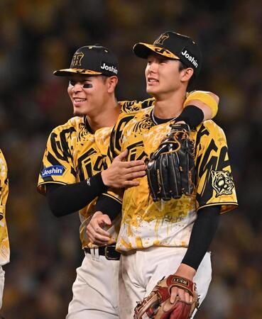 　勝利後、９回に失策した小幡（右）に声をかける佐藤輝＝１３日