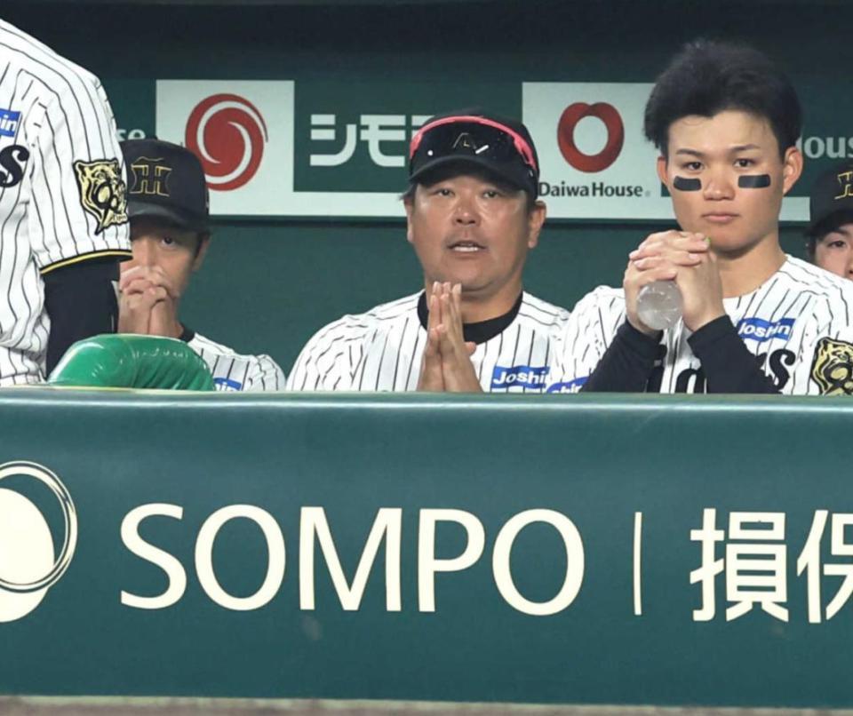 　巨人戦の９回、豊田の打席でベンチから手を合わせて祈る近本（左）＝３日