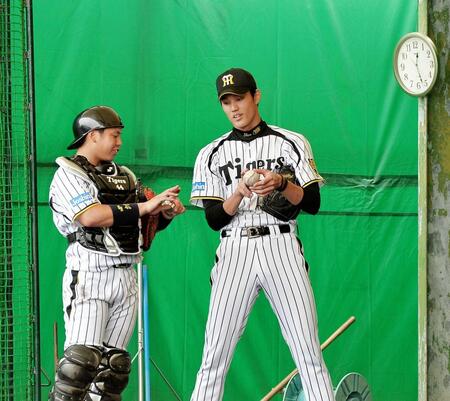 　ブルペンで投球練習を終え梅野隆太郎とボールの握りについて話す阪神・藤浪晋太郎（右）＝２０１４年
