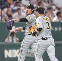 　５回、無失点に抑え、大山（右）とタッチを交わす藤浪＝２０２２年８月