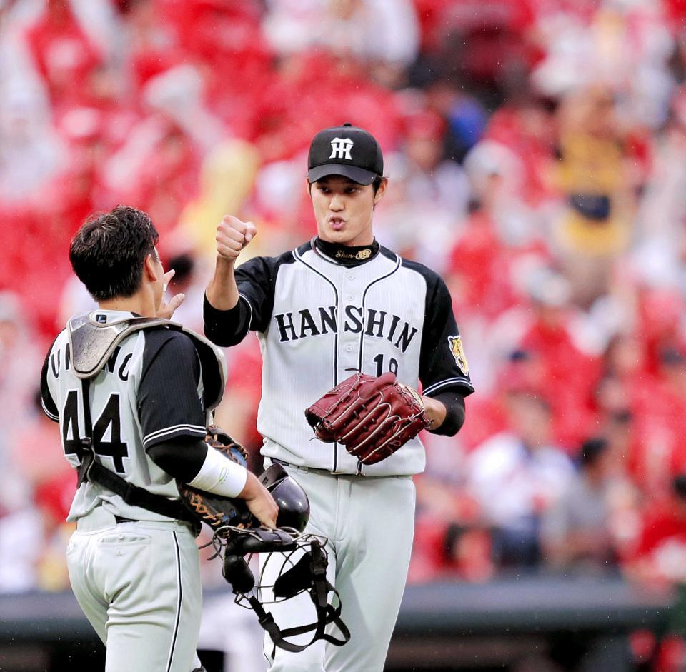 　完投勝利を飾り、梅野（左）とタッチを交わす藤浪＝２０１６年９月