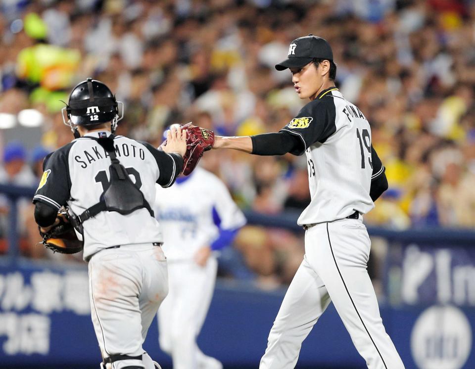 　ＤｅＮＡ・戸柱を空振り三振に仕留め、坂本（左）とタッチを交わす藤浪＝２０１６年