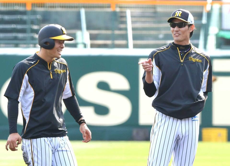 　練習中、佐藤輝（左）に話しかける藤浪＝２０２１年４月