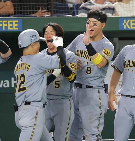 　１１回、２ランを放った坂本（左）を祝福する佐藤輝（撮影・西岡正）