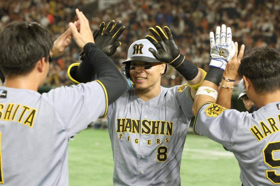 　１１回、２ランを放った佐藤輝はナインと喜び合う（撮影・田中太一）