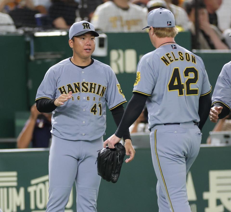 　１０回、ピンチをしのいだネルソン（右）を迎える村上（撮影・西岡正）