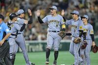 　巨人に勝利し、ナインとタッチを交わす佐藤輝（中央）＝撮影・西岡正